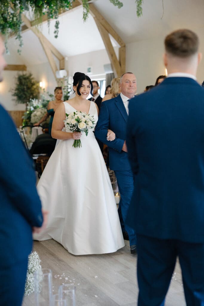 Bride walking down the aisle at the River Barn, Poulton-le-Fylde, captured by Lancashire wedding videographer Bill Nessworthy