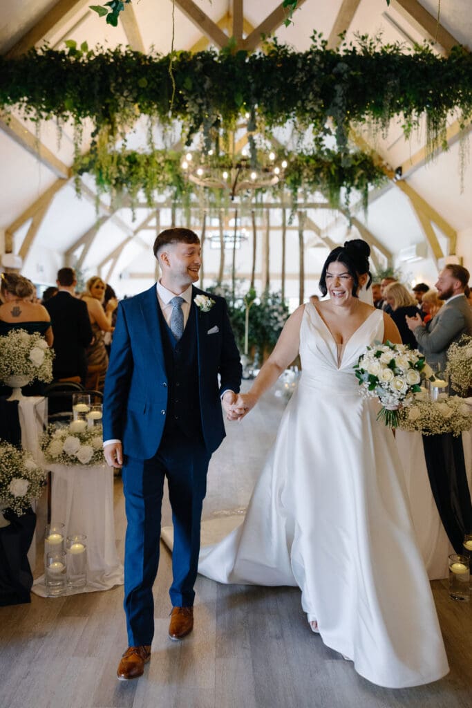 Bride and groom exit their ceremony holding hands