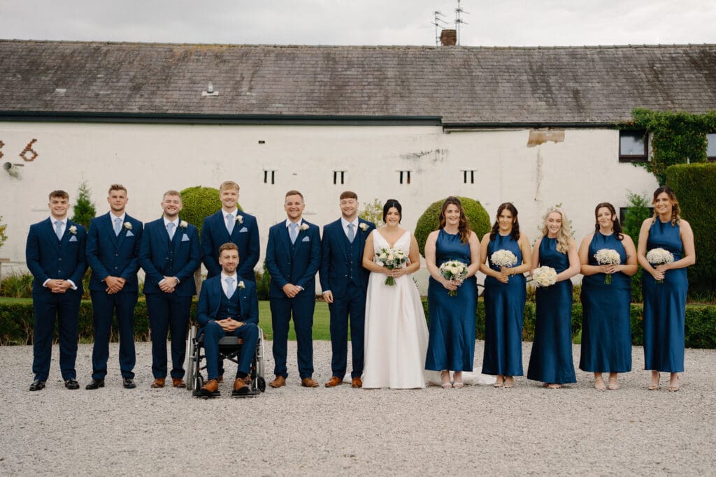 Portrait of the bridesmaids and groomsmen at the River Barn, by Nessworthy Pictures