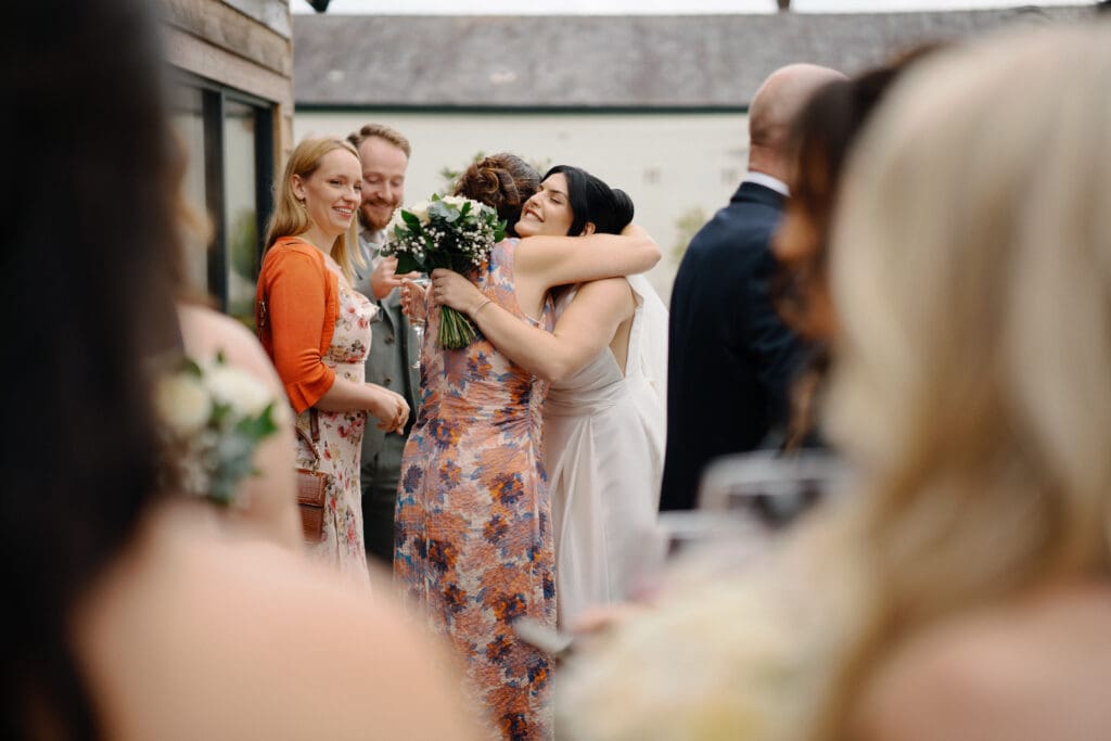 Bride hugging a guest at her River Barn wedding, by Bill Nessworthy, a Blackpool-based wedding photographer