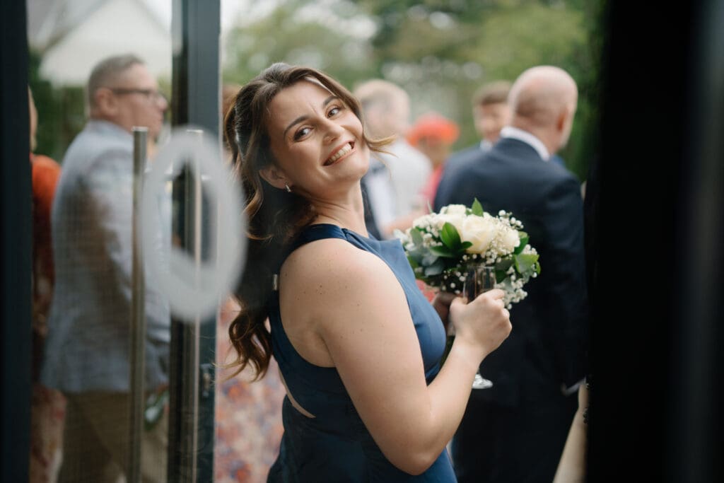 Chief Bridesmaid candid portrait through a window at the River Barn