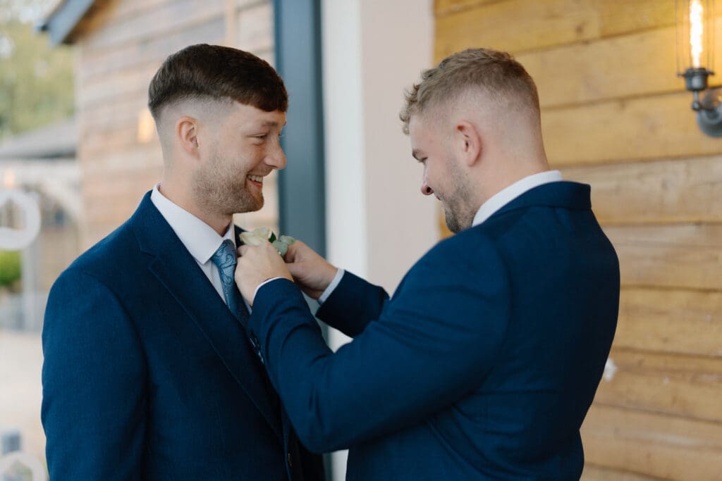 Alex's best man adjusts his boutonnière, at the River Barn, Poulton-le-Fylde, by Nessworthy Pictures