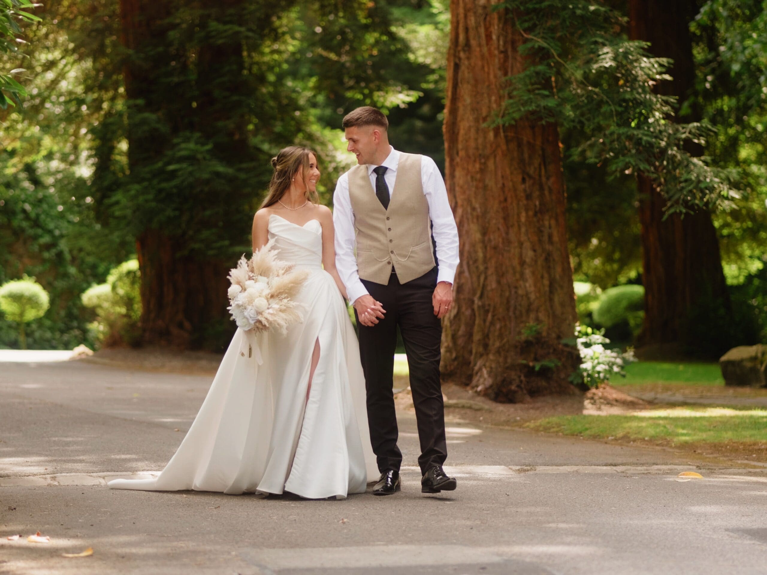 Bride and groom walking at Bartle Hall, in a still from their wedding film by Lancashire wedding videographer, Nessworthy Pictures